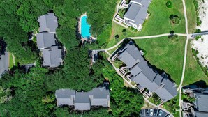 An aerial view of a residential area with multiple houses, a swimming pool, and a well-maintained lawn. - Sailmaker Gated Complex: Near Pool & Beach (Fernandina Beach)