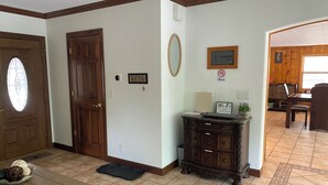 Ein Zimmer mit Holztür, einem Schild mit der Aufschrift 'KEYS', einem Rauchverbot-Schild, einem 'Wi-Fi'-Schild und einem Essbereich mit Tisch und Stühlen.