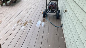 Eine Holterrasse mit einem Gartenschlauch und einem Paar Stiefel.