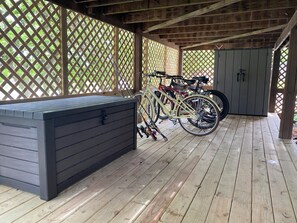Een overdekte buitenruimte met een opslagruimte, fietsen en een technische kast.