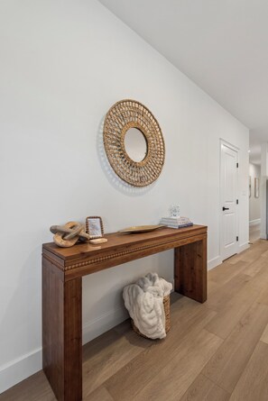 A hallway with a wooden bench, a woven wall decoration, and a door. - 158 E Garfield ave, unit 105 in the heart of Wildwood. Location parking and pool (Wildwood)