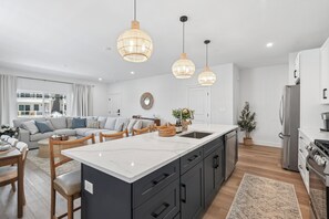 A modern kitchen with a large island, dark cabinetry, and stainless steel appliances. - 158 E Garfield ave, unit 105 in the heart of Wildwood. Location parking and pool (Wildwood)