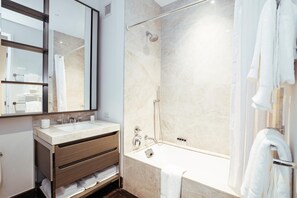 Ein modernes Badezimmer mit einer gläsernen Duschkabine, einem Waschtisch und einem großen Spiegel.