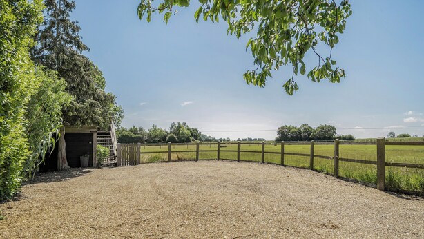 A gravel path leading to a building with a wooden fence and trees. - Hayloft-Sleeps 3-with Enclosed terrace (Dereham)