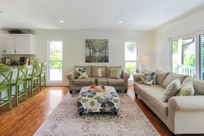 A spacious living room with a sofa set, a coffee table, and a dining area with chairs. - Private Siesta Key Pool Home Near Beaches - Siesta Sol (Sarasota)