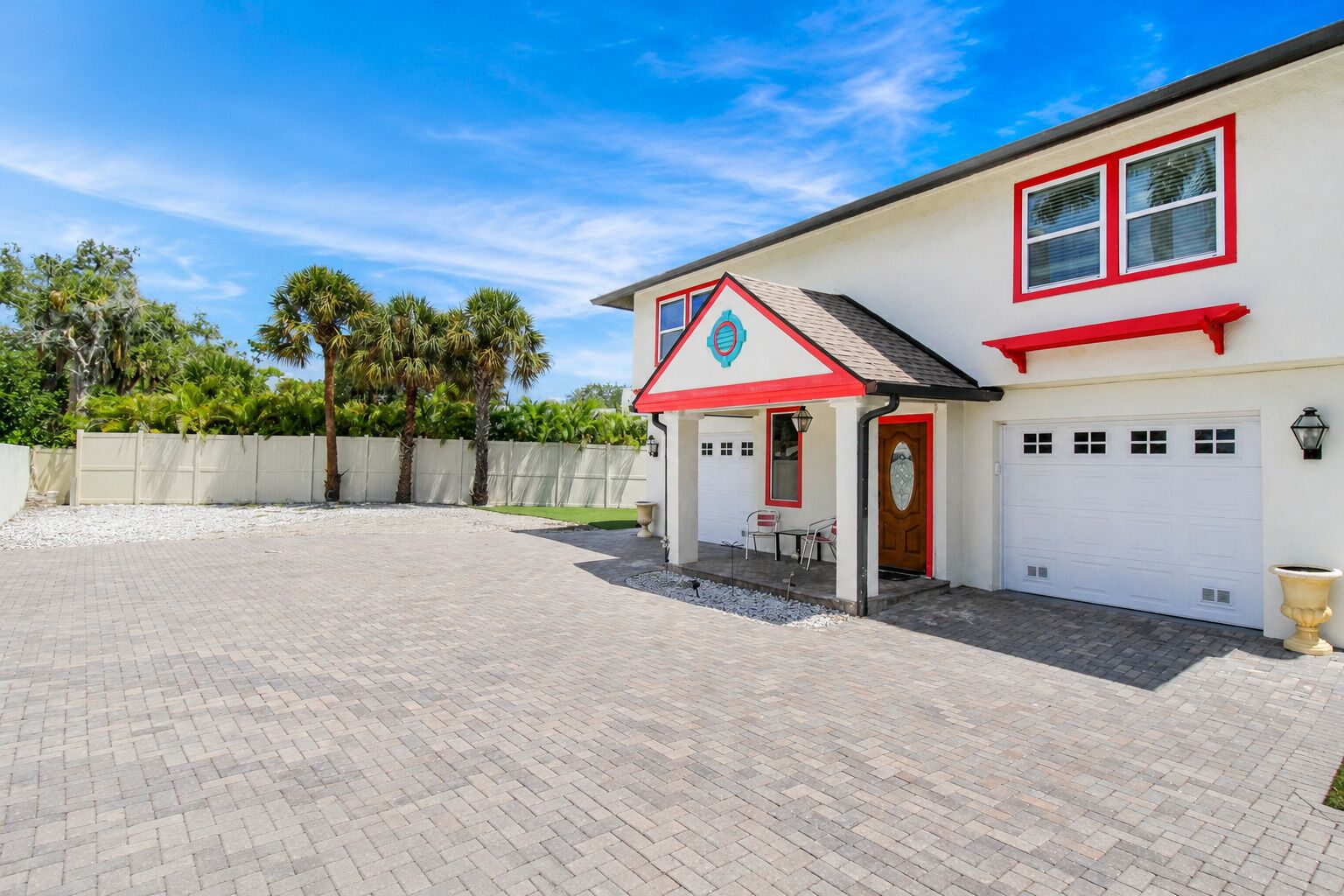 A two-story house with a garage, a covered patio, and a fenced backyard.