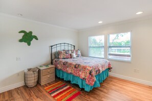 A bedroom with a bed, dresser, and a small trash bin. - Private Siesta Key Pool Home Near Beaches - Siesta Sol (Sarasota)