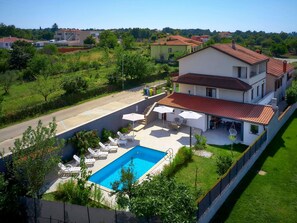 Um imóvel residencial com piscina, área de estar externa e vista para o bairro.