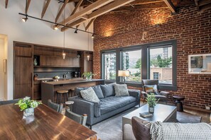 Une cuisine moderne avec des meubles en bois foncé, un îlot central et des luminaires suspendus.
