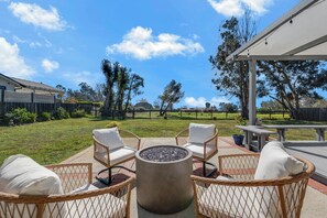 An outdoor seating area with wicker chairs and a fire pit. - Welcoming 3-bedroom house in Malibu perfect for your getaway (Malibu)