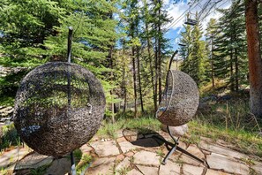 Two spherical sculptures in a forested area with a stone pathway. - Spacious 5BR Vail retreat with river views and fireplace (Vail)