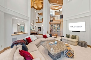 A spacious living room with a large sectional sofa, a coffee table, and a bookshelf. - Spacious 5BR Vail retreat with river views and fireplace (Vail)