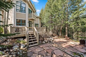 A two-story house with a stone pathway leading to a wooden deck. - Spacious 5BR Vail retreat with river views and fireplace (Vail)