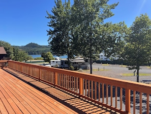 A wooden deck with a view of RVs and a lake. - Cascades Condo / Pool Access / Great Location near Foster Lake! (Sweet Home)