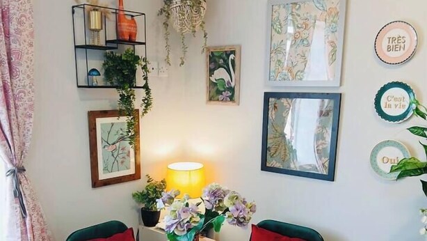 A dining area with a table set for two, a hanging light fixture, and wall decorations including framed artwork and a decorative plate. - #43 Digbeth Private Studio Apart (West Midlands)