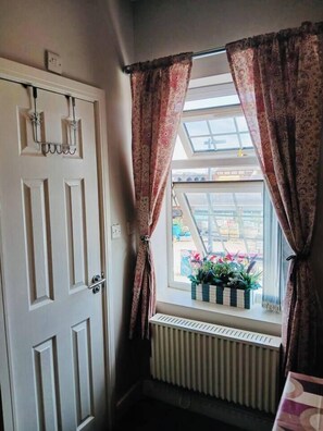 A room with a white door, a window with patterned curtains, and a radiator below. - #43 Digbeth Private Studio Apart (West Midlands)