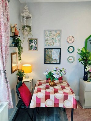 A dining area with a table, chairs, a lamp, and wall decorations. - #43 Digbeth Private Studio Apart (West Midlands)