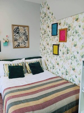 A room with a bed, a floral wallpaper, and a framed picture on the wall. - #43 Digbeth Private Studio Apart (West Midlands)