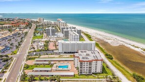 Un hôtel situé sur la côte, composé de plusieurs bâtiments, doté d’un parking et donnant accès à une plage.