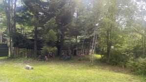Un espacio al aire libre con césped, una valla de madera y árboles.
