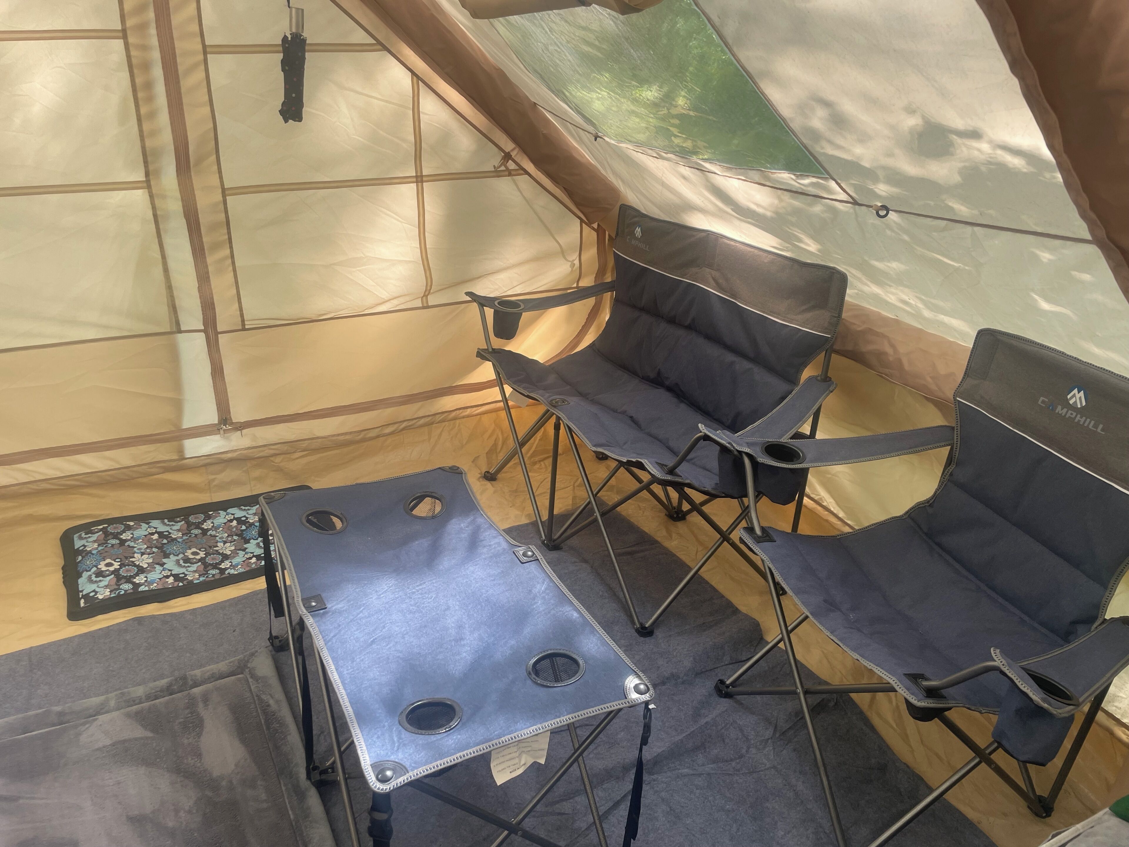 A tent interior with a table and two chairs.