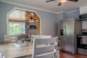 Eine moderne Küche mit Einbaukühlschrank, Mikrowelle und einem Essbereich mit Holztisch und Stühlen.