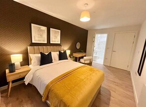 Ein Hotelzimmer mit Bett, Nachttischen, Schreibtisch und Stuhl.