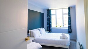 A hotel room with a bed, bedside tables, a window with curtains, and a view of the outside. - #137 StylishApart BournemouthBeach&Pier| for 10 (Bournemouth)