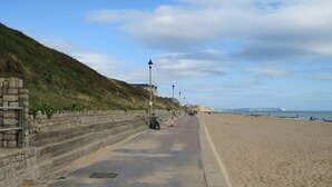 A coastal road with a stone wall on one side and a sandy beach on the other. - #137 StylishApart BournemouthBeach&Pier| for 10 (Bournemouth)