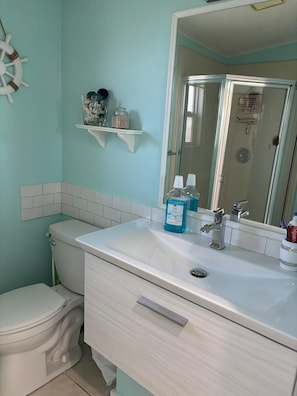 Ein Badezimmer mit Toilette, Waschbecken und Spiegel.