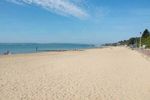 A wide sandy beach with a clear sky and calm sea. - #139 Large coastal apartment near Beach|sleeps 10 (Bournemouth)