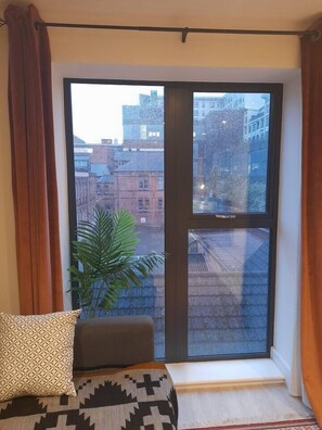 A room with a large window, a plant, and a patterned cushion. - #140 CosyFlat near Gas Street Basin&The Cube|for 5 (West Midlands)