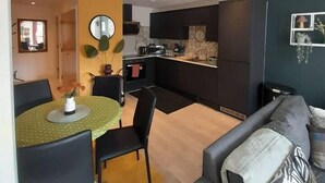 Um espaço de estar moderno, com sala de jantar, cozinha e área de estar.