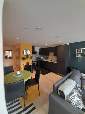 A modern living space with a dining area, kitchen, and seating area. - #140 CosyFlat near Gas Street Basin&The Cube|for 5 (West Midlands)