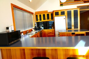 A modern kitchen with wooden cabinets, a stainless steel countertop, and a built-in oven.