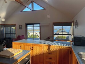 A kitchen with wooden cabinets, a countertop, and a view of the outdoors.