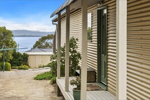 Charming cottage entry with covered porch and peaceful water views