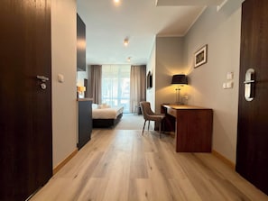 Ein Hotelzimmer mit Bett, Schreibtisch, Stuhl und Blick aus dem Fenster.