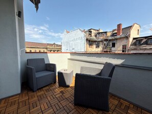 A rooftop terrace with wicker furniture, a view of historic buildings, and a clear sky. - Wrocław Główny Modern Studio (Wrocław)