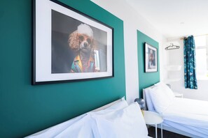 A hotel room with a bed, a chair, and a framed picture on the wall. - #141 Coastal Apartment BournemouthBeach| Sleeps 10 (Bournemouth)