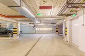 A multi-level parking garage with clear signage for exits and emergency exits. - Paryska Deluxe Apartment (Kołobrzeg)