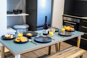 Une table de petit-déjeuner avec des assiettes, des verres, une bouteille et une bouteille de Prosecco.
