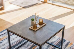 A square table with a metal frame, a small plant, and two candles on a tray. - #160 Cozy House at Electric Wharf-For Contractors (West Midlands)