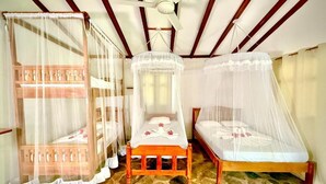 A room with three wooden beds, each with a canopy, and a ceiling fan. - finca montania sagrada Ometepe (Mérida)