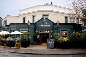 Un edificio con un letrero que dice 'THE LIBERTINE' en la entrada.