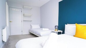 Ein Hotelzimmer mit einem Bett, einem Nachttisch mit einer Lampe und einem Kleiderschrank.