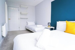 Ein Hotelzimmer mit einem Bett, einem Nachttisch mit einer Lampe und einem Kleiderschrank.