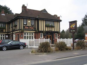 A traditional pub named 'The Hut' with a white fence and potted plants in front. - #150 Bright Apt – Westbourne Area - Sleeps 7 (Bournemouth)