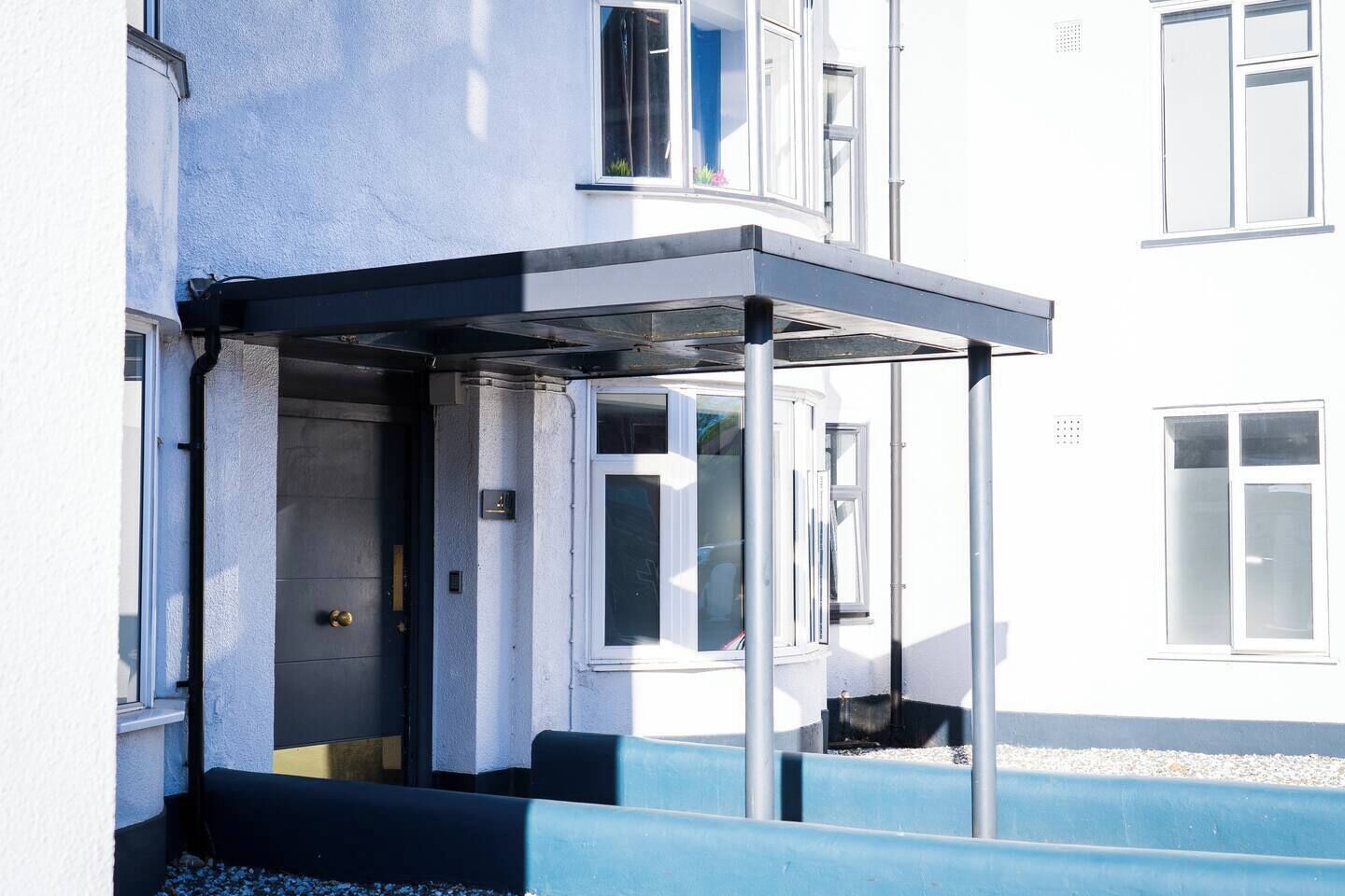 A building with a covered entrance, a door, and a window.