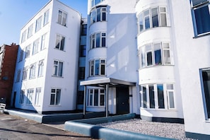 A multi-story building with a white facade, multiple windows, and a curved corner entrance. - #149 Stylish Apart. Near WestbourneCentre|Sleeps10 (Bournemouth)